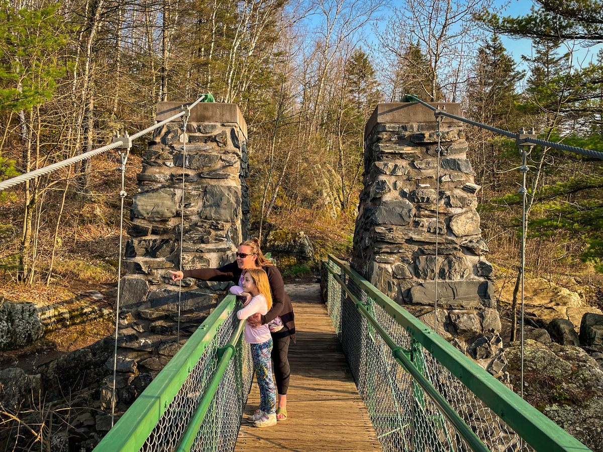 Antonia and her daughter stand on the swinging bridge at Jay Cooke State Park.