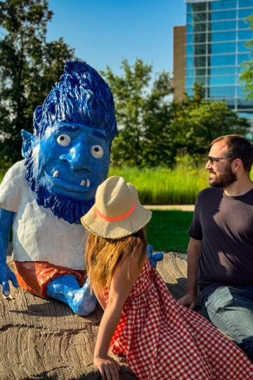 A man and his young daughter sit with OMAR, Omaha's iconic troll friend.