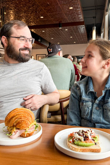 A dad and his young daughter eat pastries in Winona.