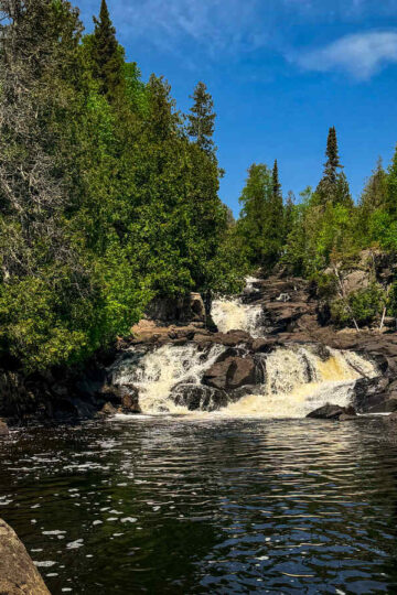 Antonia stands near the waterfall at George Crosby Manitou State Park.
